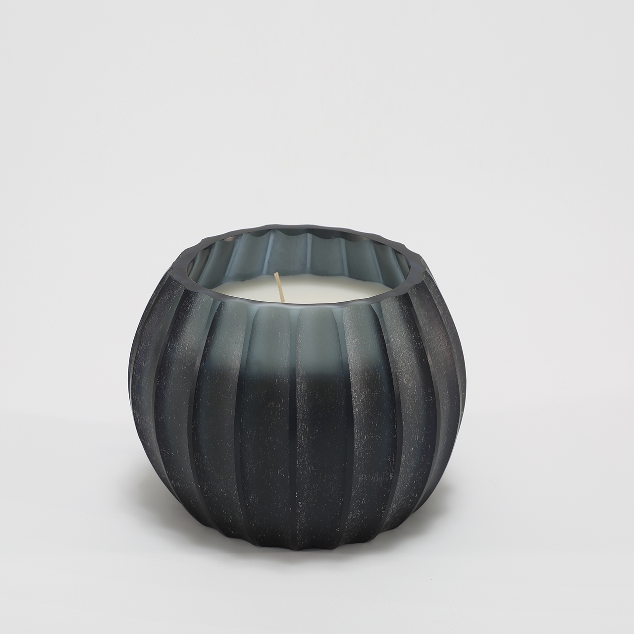 Atolla Blue Bottle Candle burning, releasing Red Santal fragrance in handcrafted blue glass vessel