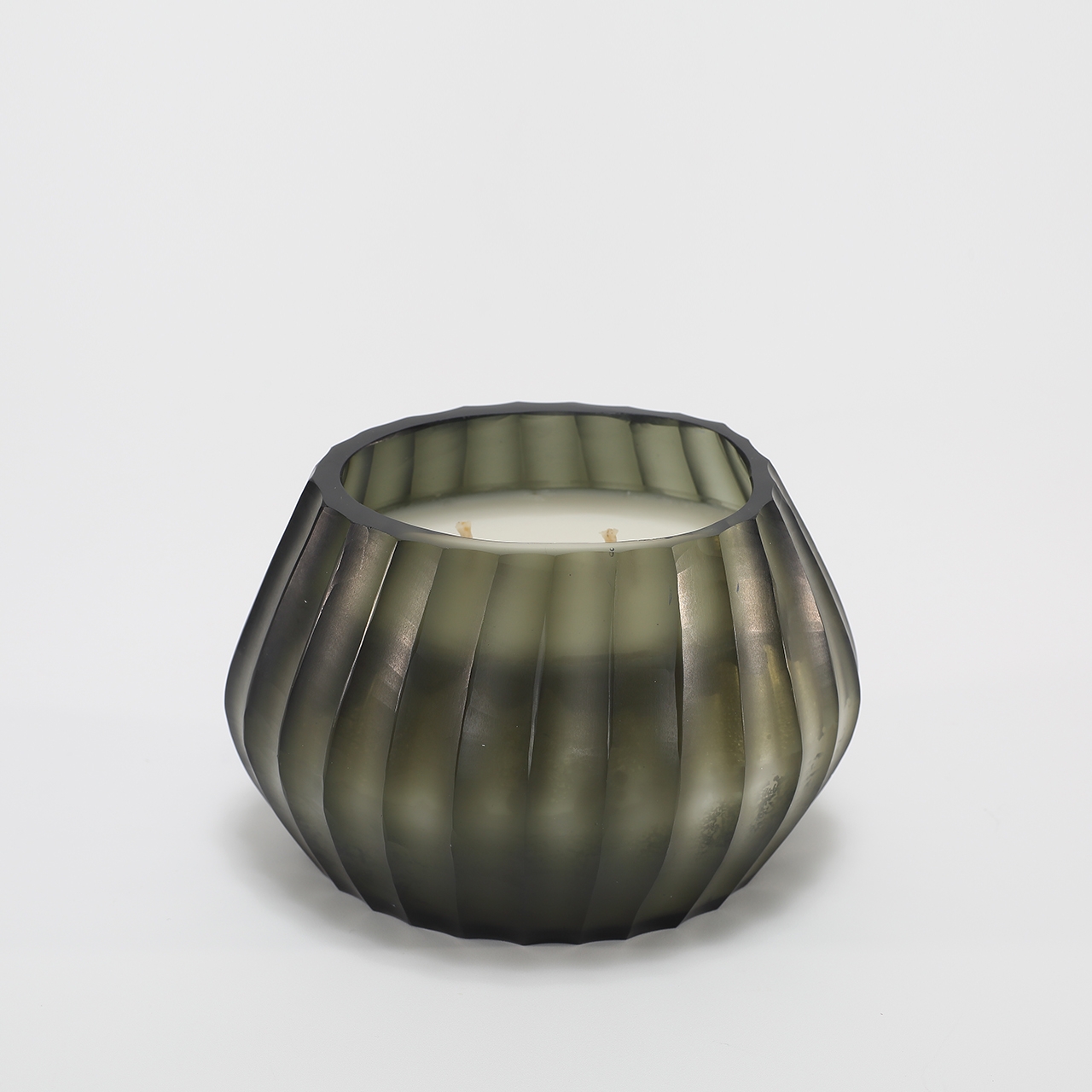 Aura Moss Candle burning, releasing Wanderlust fragrance in hand-carved glass vessel