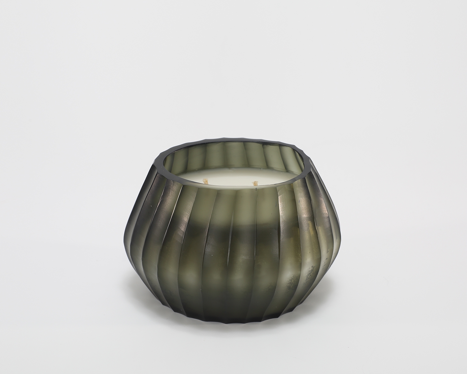 Aura Moss Candle burning, releasing Wanderlust fragrance in hand-carved glass vessel
