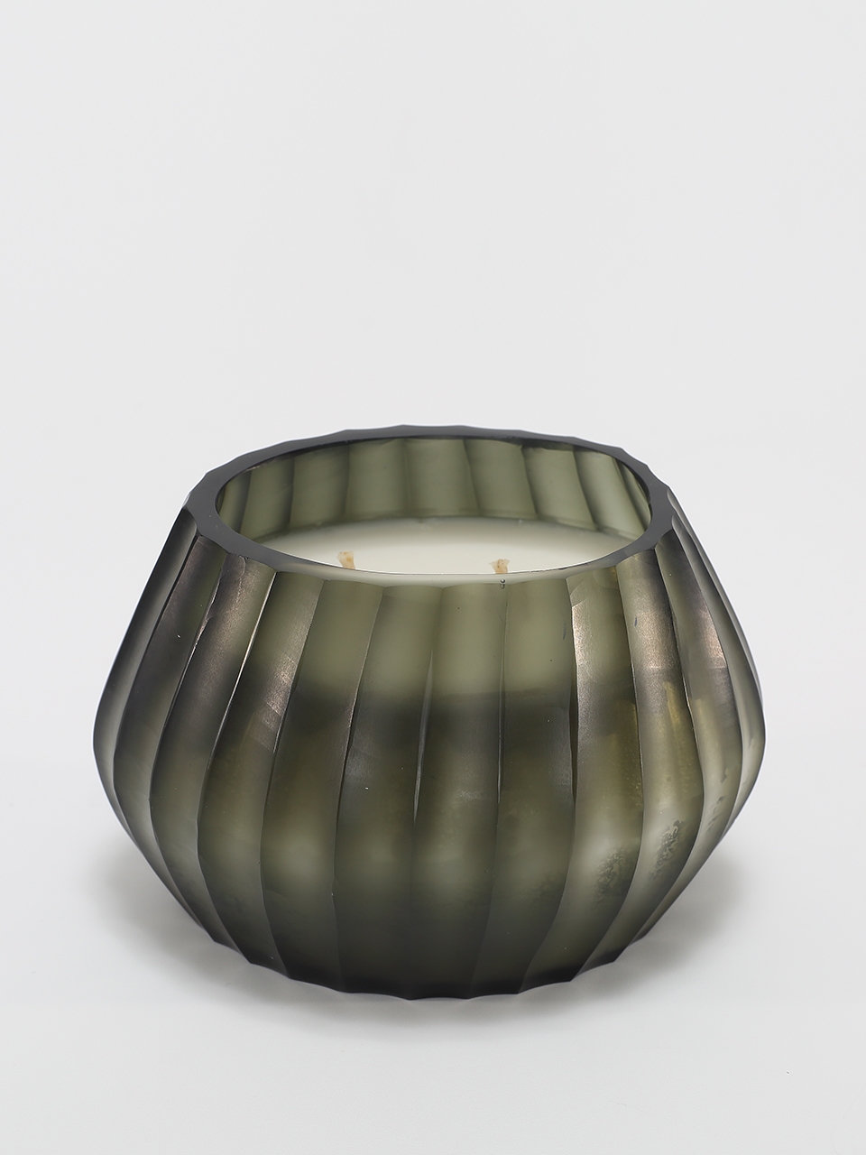 Aura Moss Candle burning, releasing Wanderlust fragrance in hand-carved glass vessel