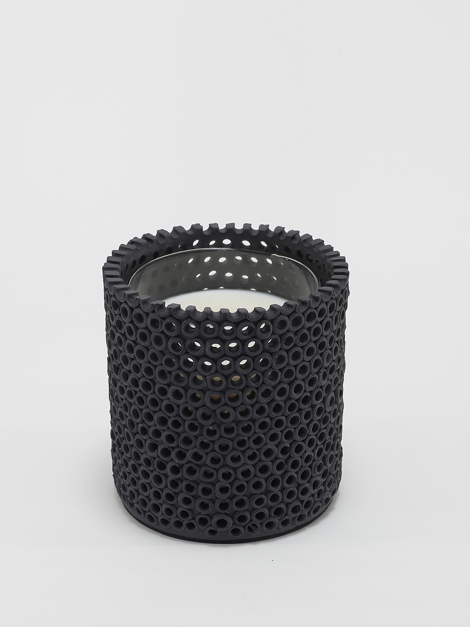 Coralite Ebony Candle burning, releasing Noir fragrance in handmade ceramic vessel