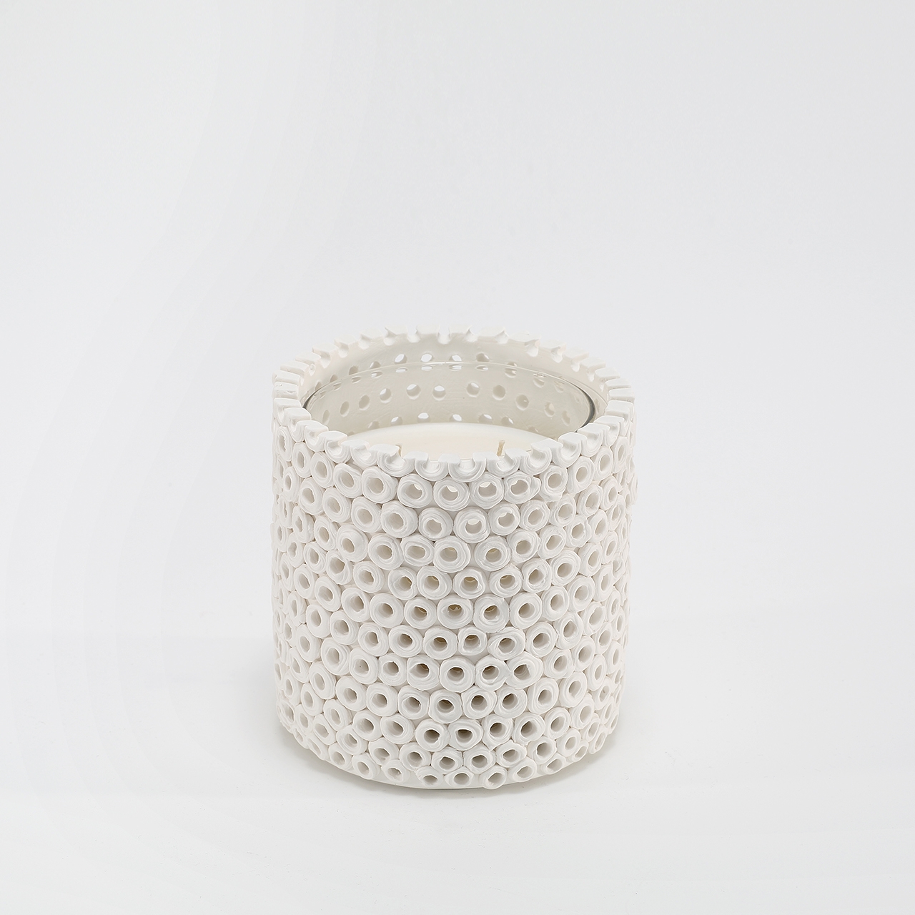 Coralite Ivory Candle burning, releasing Coastal Wilderness fragrance in handcrafted ceramic vessel