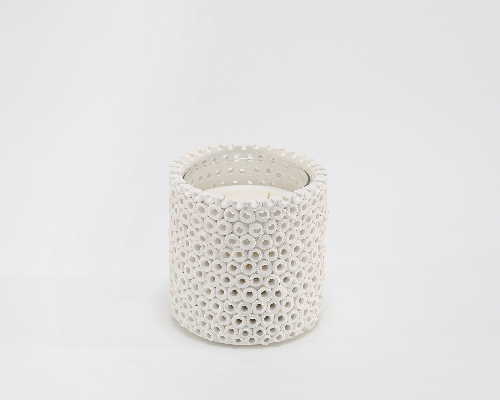 Coralite Ivory Candle burning, releasing Coastal Wilderness fragrance in handcrafted ceramic vessel