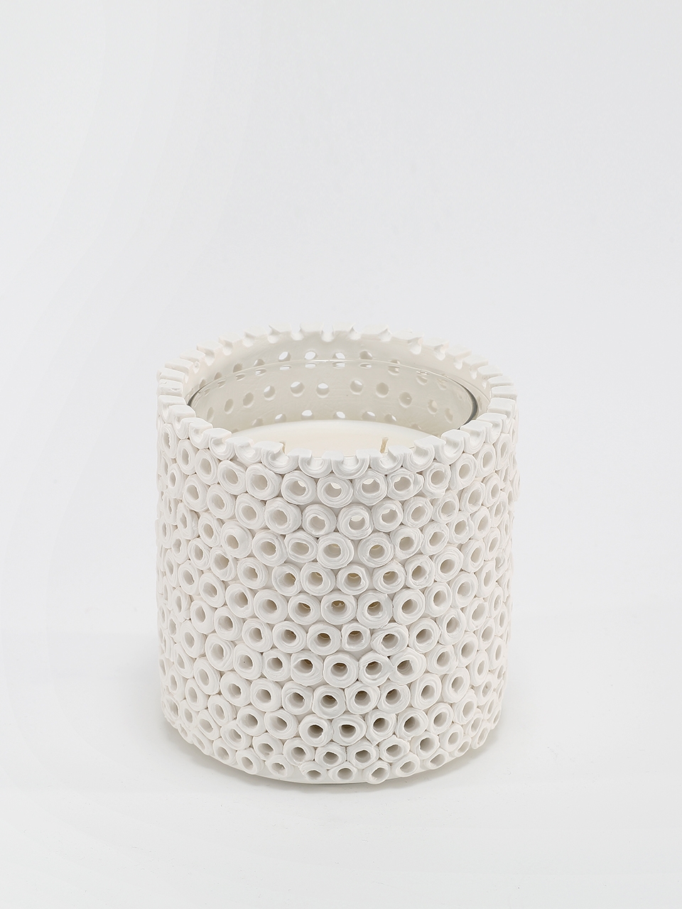 Coralite Ivory Candle burning, releasing Coastal Wilderness fragrance in handcrafted ceramic vessel