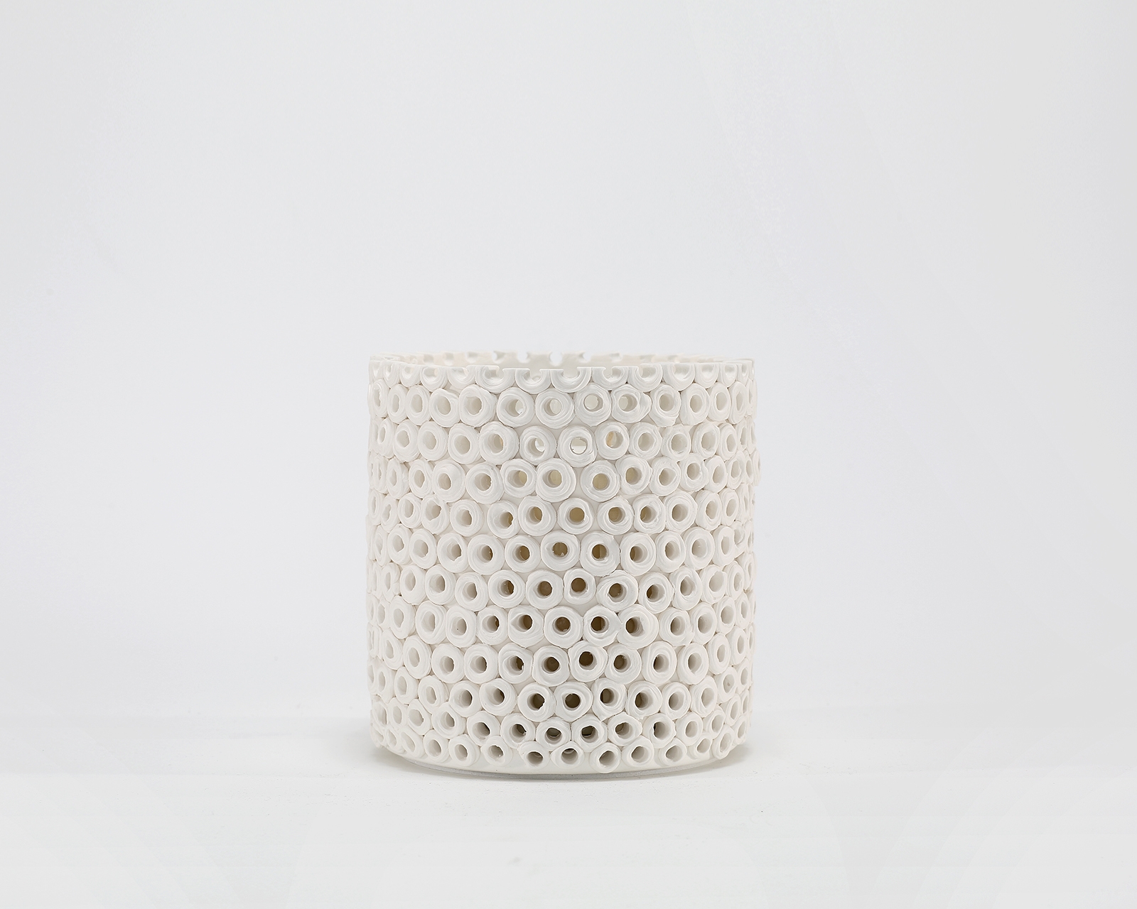 Coralite Ivory Candle burning, releasing Coastal Wilderness fragrance in handcrafted ceramic vessel